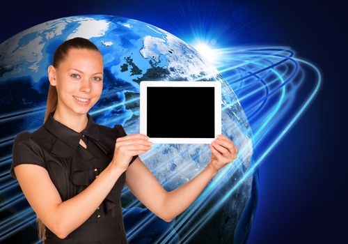 Smiling young woman holging tablet looking at camera on earth model background. Connection all over the world. Elements of this image furnished by NASA