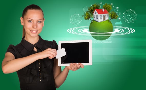 Businesslady holging tablet and blank card with green 3d Earth model with circles, trees, house around and looking at camera on abstract green background