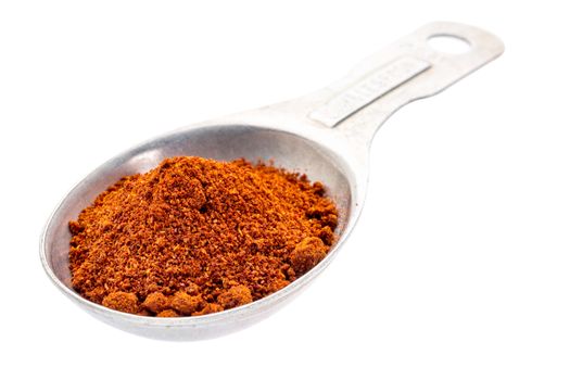 paprika powder on an old aluminum measuring spoon isolated with a clipping path