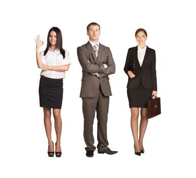 Team leader stands with coworkers in background and in looking at camera on isolated white background