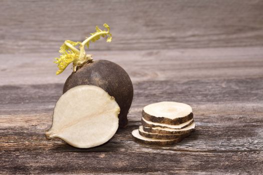 Black radish on wooden background