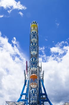 Giant ferris wheel against blue sky and white cloud