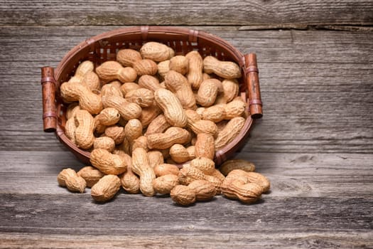 peanuts in basket on old wood background