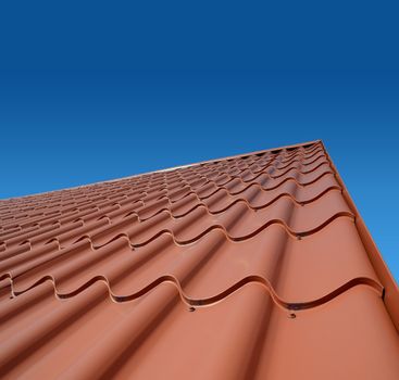 new roof with orange sheet metal and background of blue sky