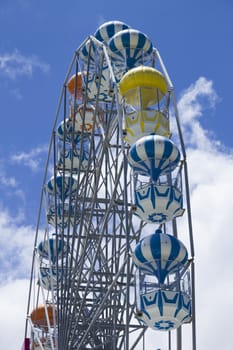 Giant ferris wheel against blue sky and white cloud