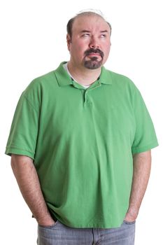 Portrait of Overweight Man Wearing Green Shirt Standing with Hands in Pockets and Looking Up Thoughtfully on White Studio Background