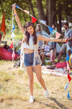 Pretty hipster posing for camera with flags at a music festival 