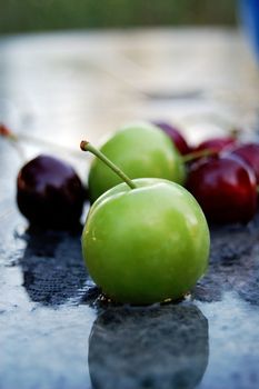 Picture of a Green Plum on a wet surface