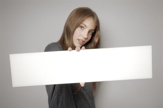 An image of a beautiful teenage girl holding a white board