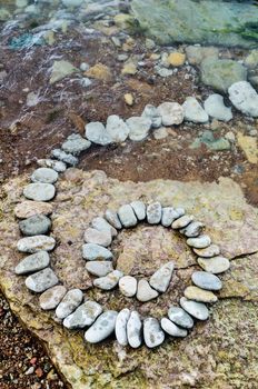 Spiral of pebbles on the stony coast