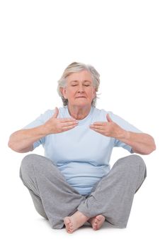 Senior woman doing yoga exercise on white background