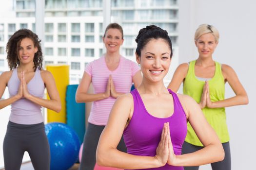 Portrait of happy women with hands joined exercising at gym