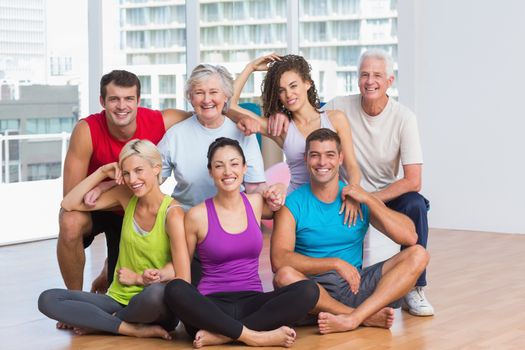 Full length portrait of happy people in sportswear at fitness studio