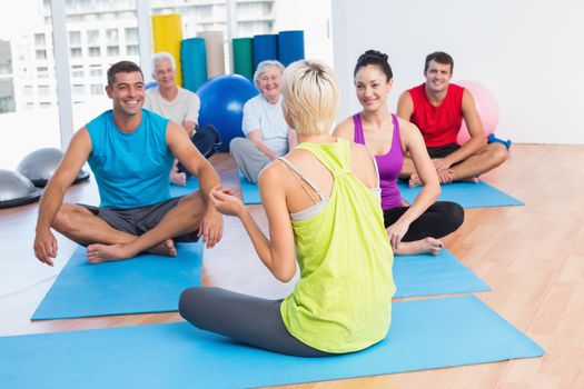 Female instructor talking with class in fitness club