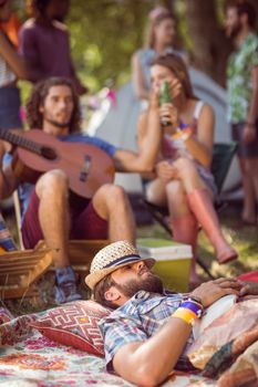Handsome hipster relaxing on campsite at a music festival 