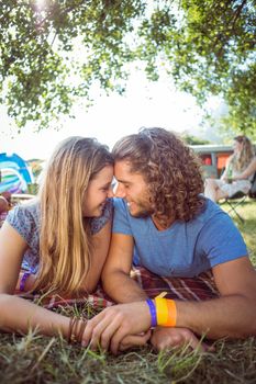 Hipster couple smiling at each other at a music festival 