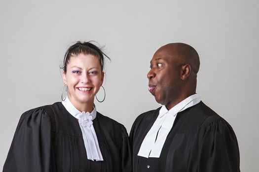 bald black man making a face to a woman, both wearing canadian lawyer toga