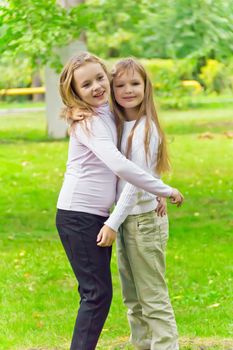 Photo of two embracing girls in summer