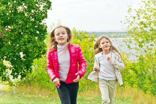 Photo of two running girls in summer