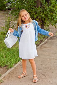 Cute girl playing with white bag in summer