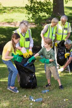 Happy family collecting rubbish on a sunny day