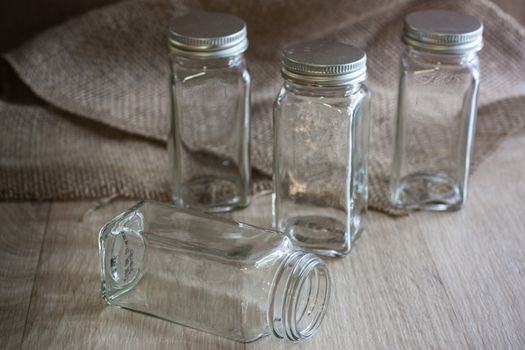 Vintage style glass bottles on a wooden surface with natural light coming in from a window to the right .