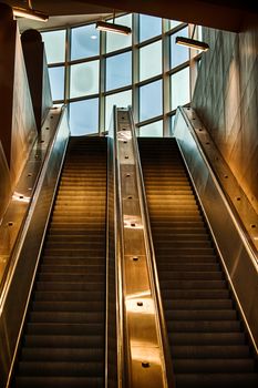 An escalator going up indoor gold tones