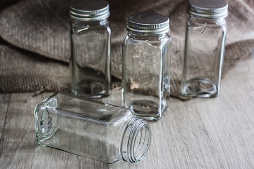 Vintage style glass bottles on a wooden surface with natural light coming in from a window to the right .