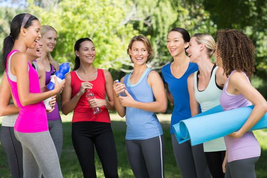 Fitness group chatting in park on a sunny day