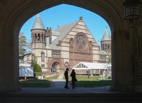 PRINCETON, NJ - OCTOBER 20: Colorful autumn in one of the best and oldest universities in USA, belonging to elite Ivy Leaque, classified at the 1-st place in ranking. Students standing under gate in Blair Arch with view at beautiful Alexander Hall, October 20, 2013 in Princeton, NJ