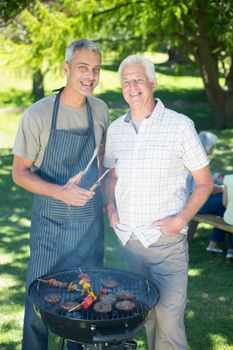 Happy man doing barbecue with his father on a sunny day