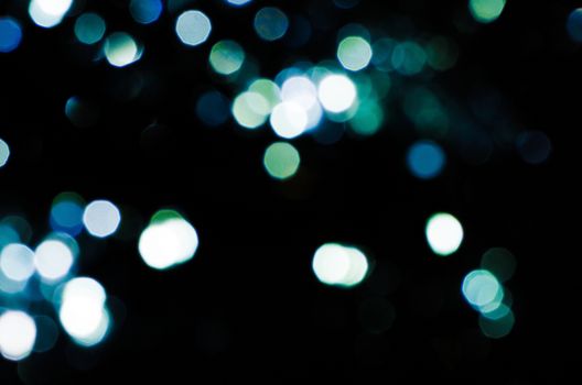 Black background with green and blue blur circles.