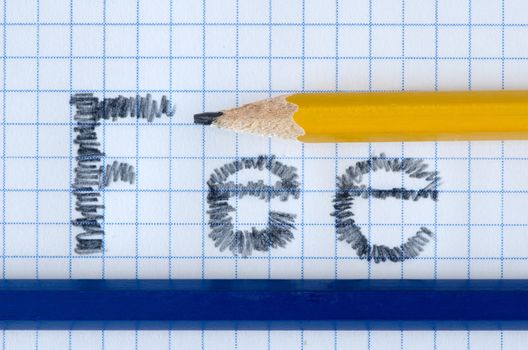 Fee word typed on white paper, yellow and blue pencil.