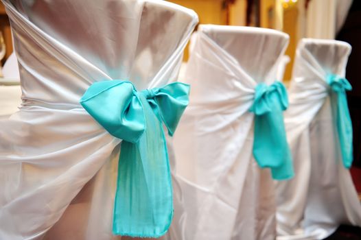 wedding decorations in the restaurant chairs with white cover.