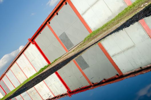 A lot of garages, puddle with reflection.