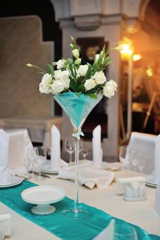 wedding decorations in the restaurant with flowers on table.