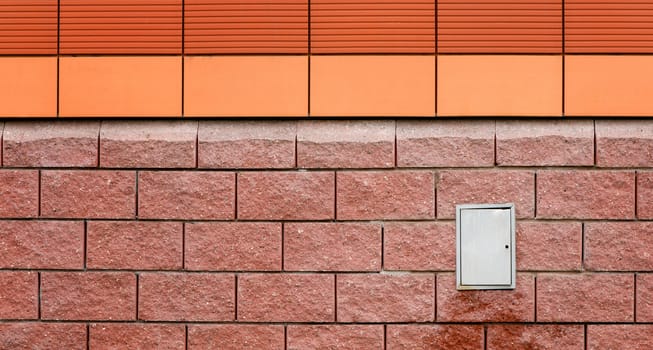 Orange wall and red concrete block with switchboard. 