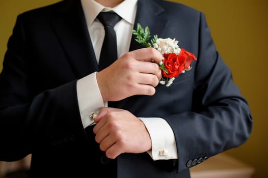 Wedding details, cufflinks, elegant male suit and hands.