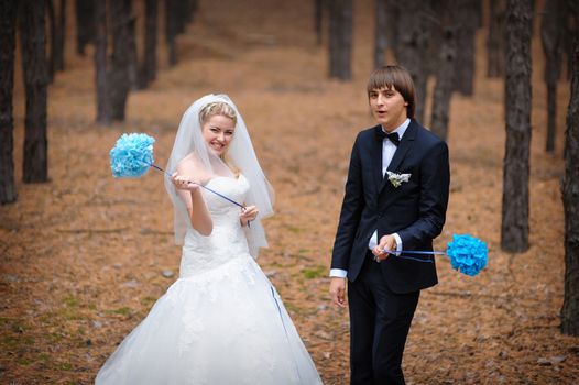 sunlight bride and groom standing in a pine forest in autumn.