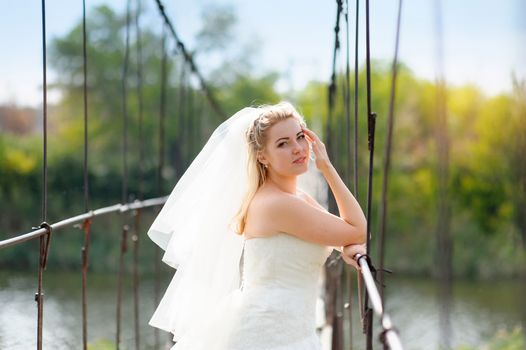 beautiful bride stands on the bridge.