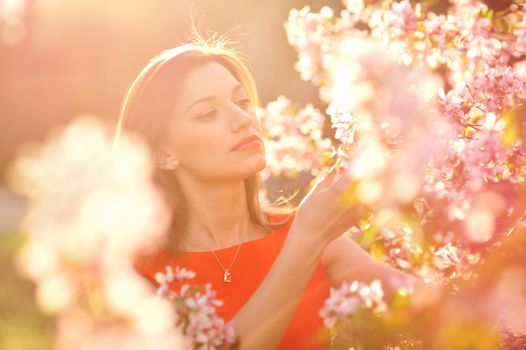 Beautiful woman among blossoming trees.