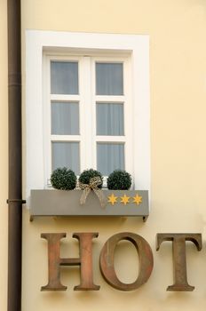 Three stars hotel's window, yellow fasade and brown eaves. 