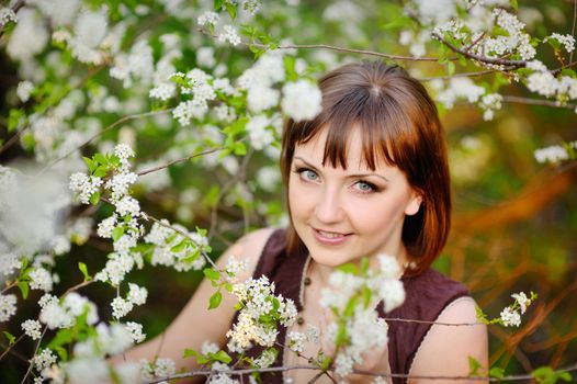 Beautiful woman in spring with blooming trees.