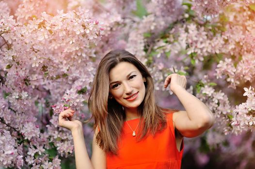 beautiful girl in red dress and flowering trees.