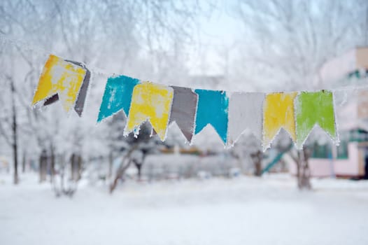 colored flags on a rope on the street in winter.