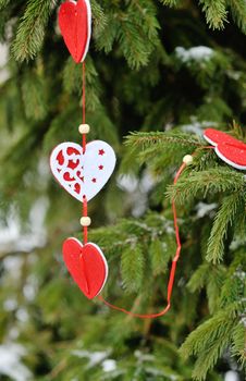 beautiful decorations of hearts on a green Christmas tree.
