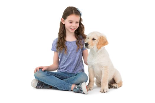 Smiling little girls sitting next to dog on white background 