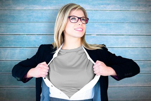 Businesswoman opening shirt in superhero style against wooden planks