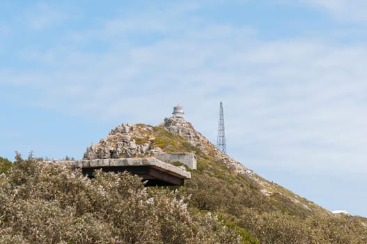 CAPE TOWN, SOUTH AFRICA - DECEMBER 12, 2014:  View from Dias Point at Cape Point towards the historic first lighthouse with a derelict military observation post from World War II in front