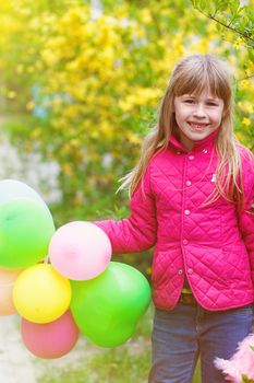 Outdoor portrait of a cute young  little girl playing with balloons